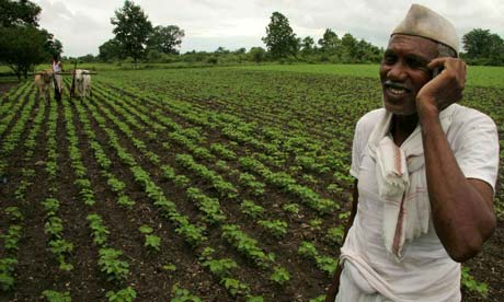 A farmer smiling while talking on the phone